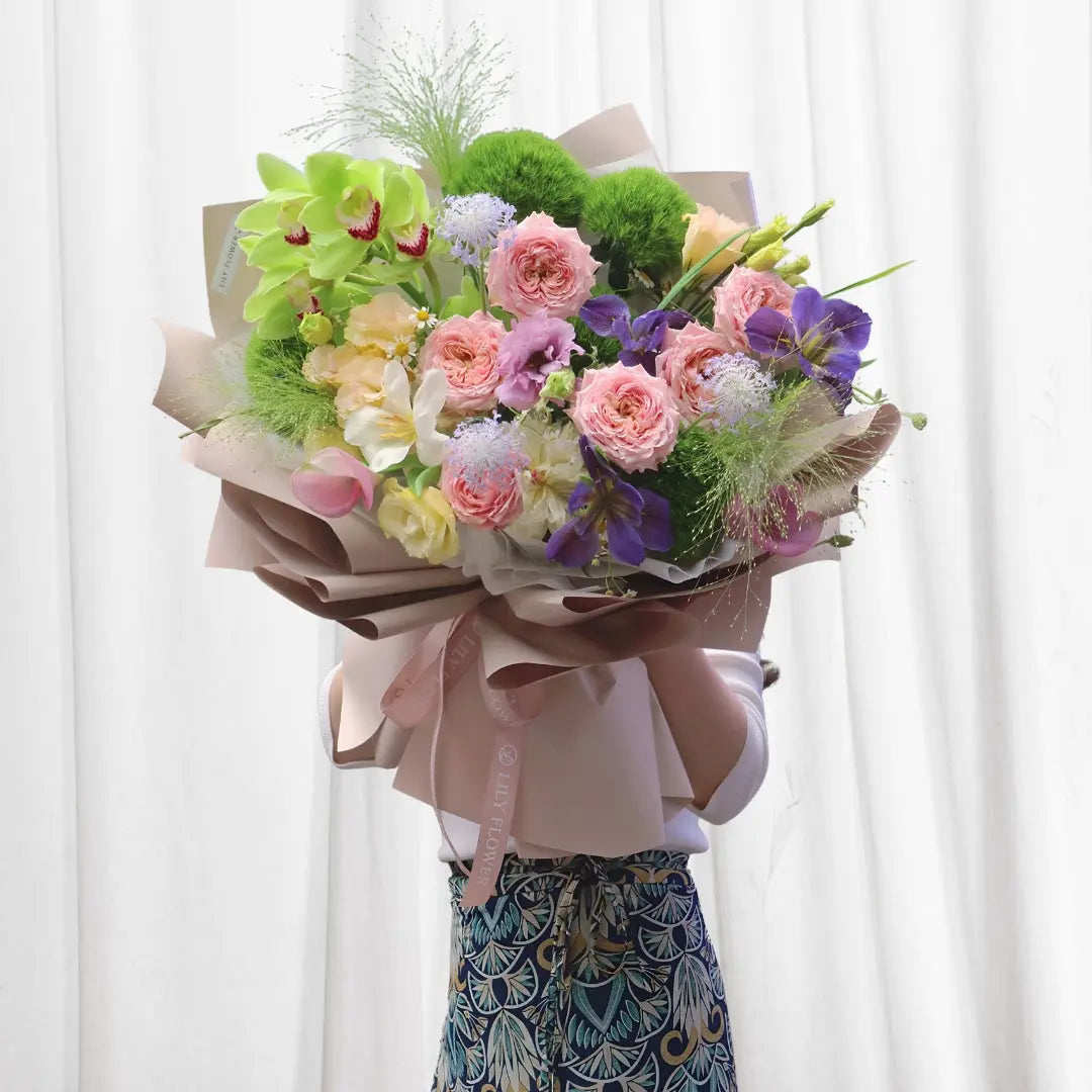 Flower Bouquet of 8 Pink Roses, 3 Soft Pink Peonies, 3 Bright Green Cymbidium Orchids with Red Markings, 3 White Soft Pink Calla Lilies, 4 Small Blue/Purple Agapanthus or Allium Sprigs, 3 Bright Green Button Mums, 3 Purple Iris Flowers, Greenery Filler Grasses