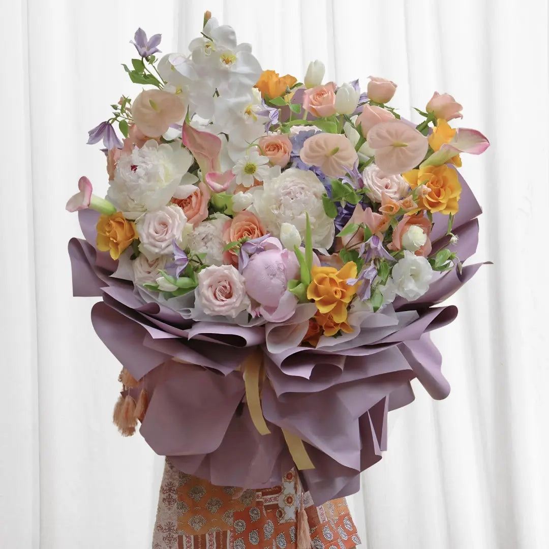 Radiant Sunrise Harmony Bouquet featuring soft pink roses, peonies, calla lilies, tulips, and vibrant spring flowers