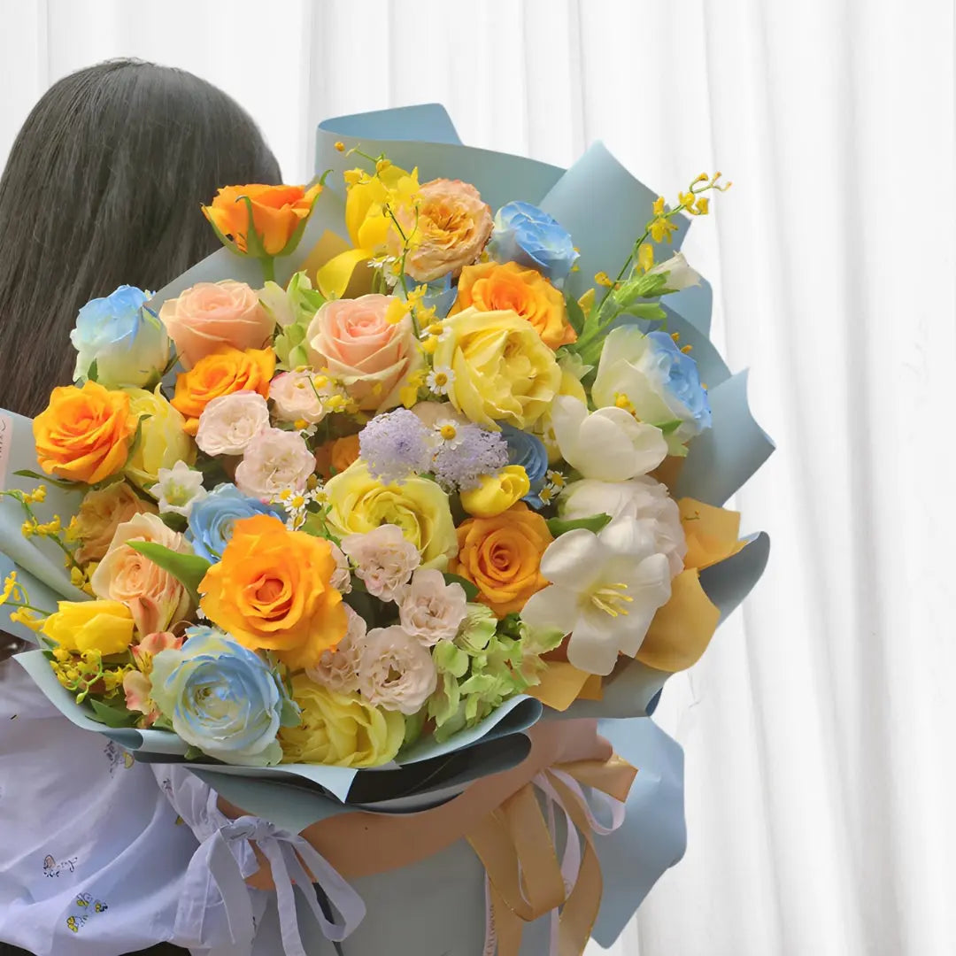 Sunset Dream Bouquet with Yellow, Pink, and Orange Roses, White Tulips, and Blue Larkspur  Elegant Floral Arrangement in Hong Kong