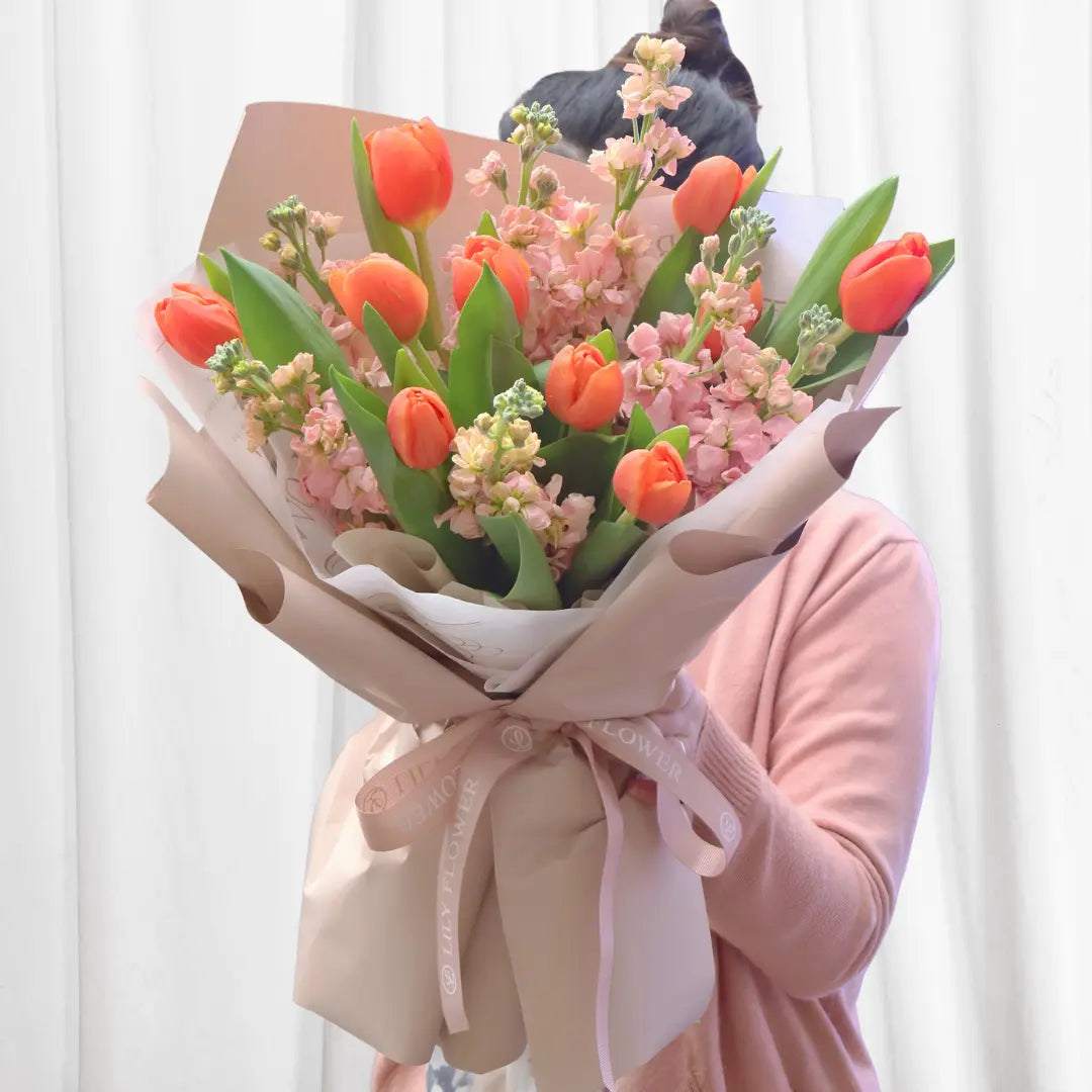 A vivid orange tulip bouquet with light pink stock flowers, perfect for Hong Kong flower delivery.